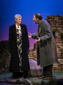 Bill confronts his wife Madeline after she comes back to him from wandering the hills searching for the remains of their Son, Adam. Bill, standing next to Madeline, his hands in a pleading gesture, tries to convince her that she must move on after seven years of grieving. Madeline can barely look him in the eyes.