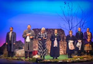 Full cast of "The Women of Lockerbie" on stage at the final scene, washing the clothes in the river. Standing to take the audience applause as the curtain prepares to close.